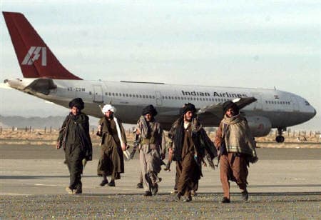 Taliban militants walking past the hijacked IC 814 flight at Kandahar Airport, Afghanistan (December 27, 1999)