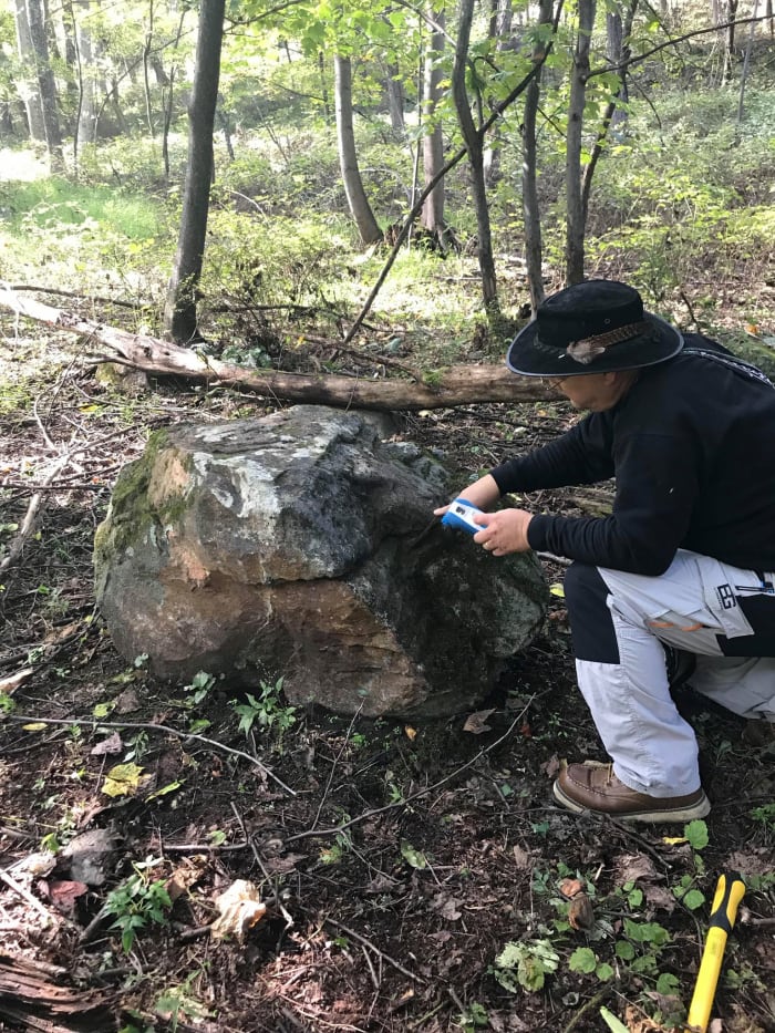 Matthew "Maasaw" Howard is cleaning off the lichen of the rock on his property to reveal something spectacular.