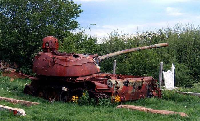 Soviet-built T-55-tank used by Serbian military lies in ruins near Prizren, Kosovo, years after the Serbs left. 2005.