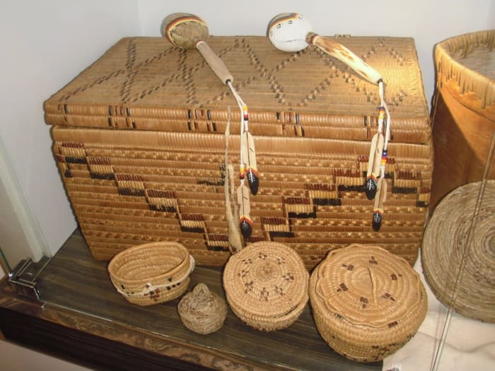 These interior Salish baskets are woven from pine needles, in front, and split cedar root decorated with darker cherry bark, rear. The collection is displayed in the House of Learning at Thompson Rivers University, Kamloops.