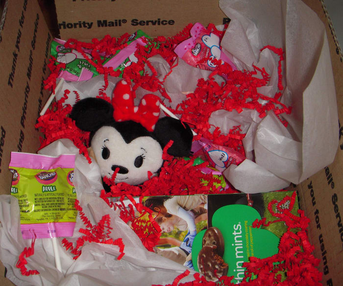In this Valentine's-Day-themed box, I used hard candy, crinkle paper, and tissue paper for cushioning. This all fit in a USPS medium flat rate box.
