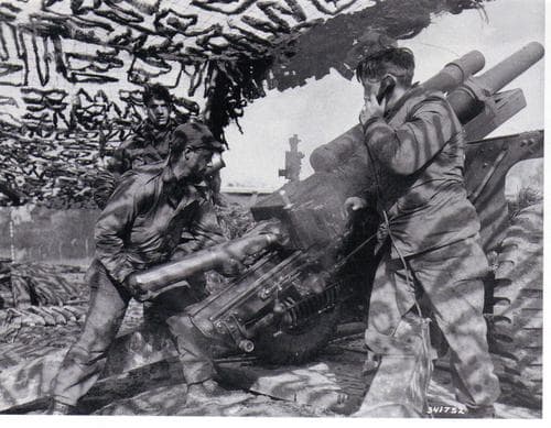 A 105mm howtizer crew preparing to fire (28th ID). The gunner corporal, who operates the quadrant (scope measuring deflection), stands to the left.