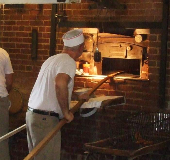 Old-fashioned techniques: Using a peel to put pretzels into the brick oven at Shuey's Pretzels, Lebanon, PA.