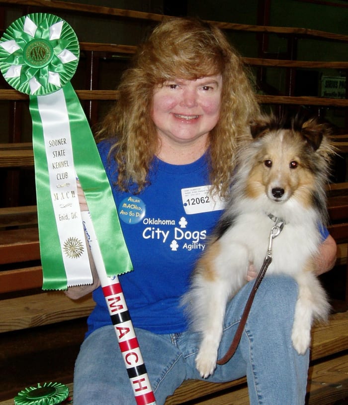 The author and her sheltie, Aslan, with his first MACH (Master Agility Championship) ribbon and MACH bar in 2006.