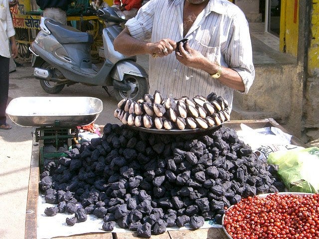 Singhara is a black-colored fruit with a white seed, as seen in this photograph.
