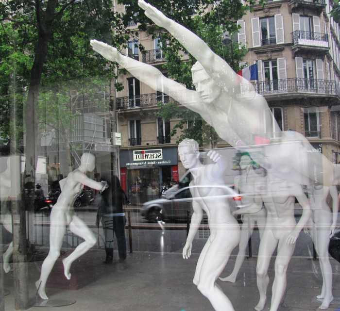 A mostly male group of mannequins cavort in their birthday suits in a Paris shop window.
