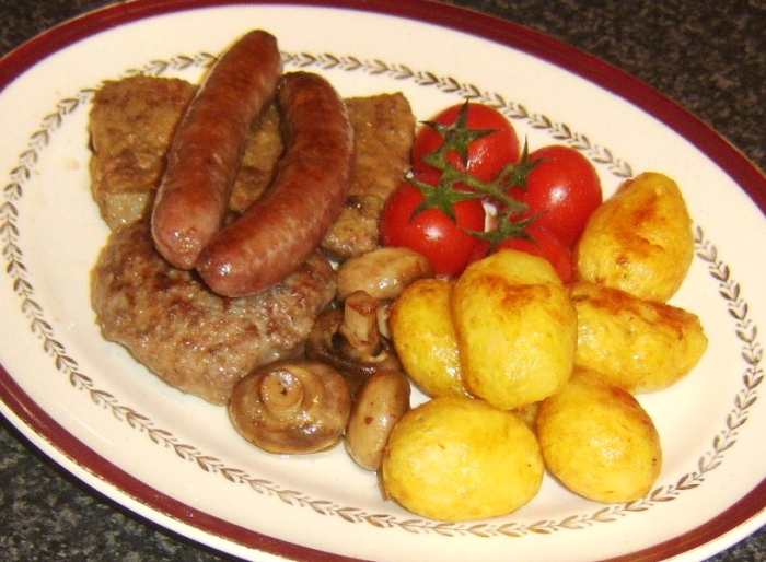 Fried ox liver is served with beef sausages, a homemade beef burger, deep fried potatoes, tomatoes and mushrooms.
