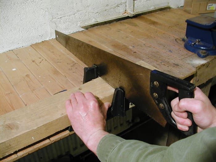 This miter box has a "lip" or hook on the underside which allows it to be pushed tightly against the edge of a bench