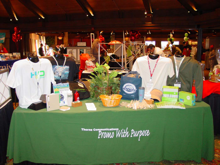 A bold color tablecloth with logo, large 3D display for products and floral accent helped gain high impact with low cost for this small trade show booth.