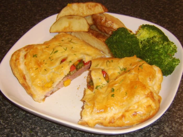 Gammon steak en croute with spicy pineapple stuffing is served with broccoli and deep fried potato wedges