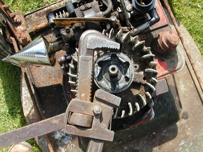 Use a pipe wrench (Stillson) to remove this piece. Keep the jaws away from the screw lugs to avoid damaging them.