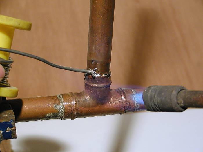 Heat the fitting with a blowtorch until a ring of solder appears. Fittings without an integral ring of solder must be "fed" with solder wire.