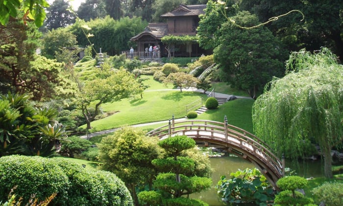 Japanese Zen––typified by peaceful, curving shapes of green rolling hills, round-canopied trees and bushes, and bridges over streams of slow-moving koi.