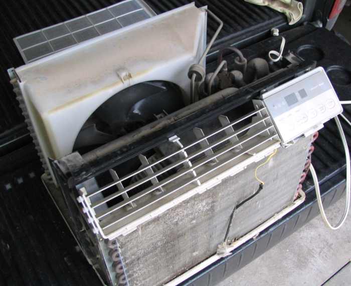 Removing the case exposes the coils, fan, and compressor. In a larger window unit, after the front plastic and a few screws are removed, the air conditioner will slide out of the case toward the inside of the room.