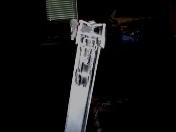 Roller assembly. The top screw is to remove the assembly, while the lower on is the adjustment screw and is reached through a hole in the door frame.