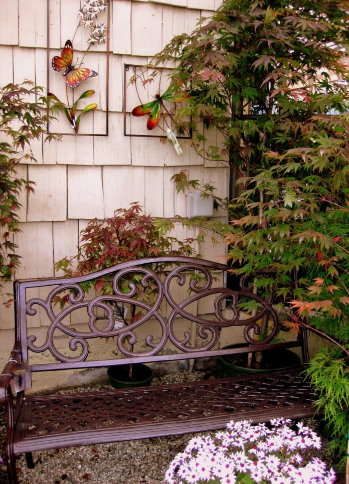 A single bench, potted plants, and some wall art can transform the back of a shed or garage.