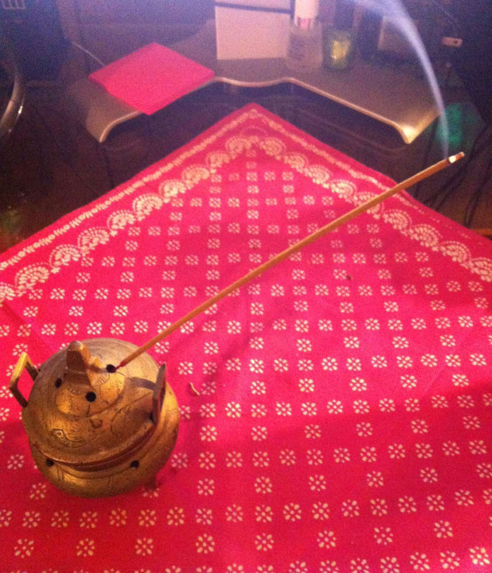 Lit stick incense should be angled up and have something on the surface to catch ashes.