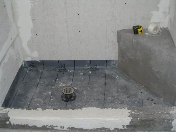Notice the wall boards do not extend down to the bottom of the shower membrane.
