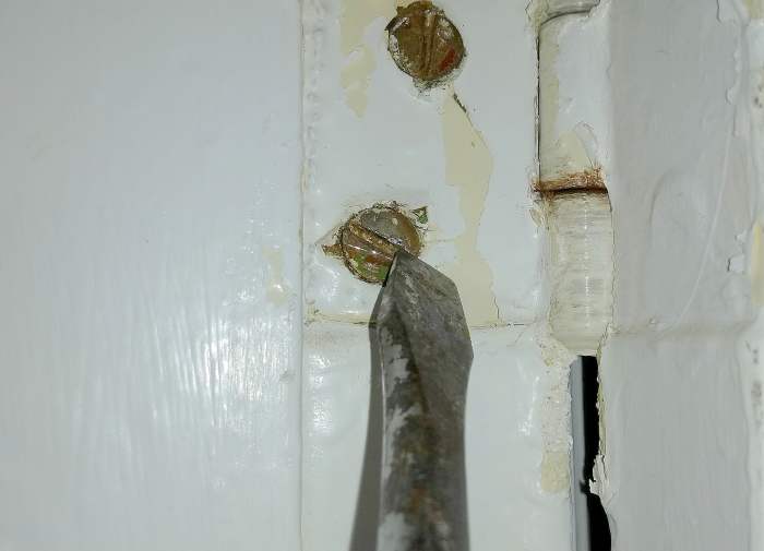 Hammer at right angles to the slot, near the perimeter. This may help to un-stick the screw.
