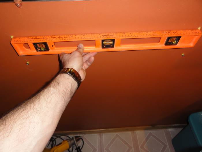 Use your level to ensure your top left and right marks are level and appropriately spaced. Do the same for your bottom left and right marks (ignore the wall anchors in this image).