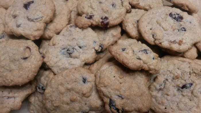 A batch of oatmeal raisin cookies made with cherries and cranberries.