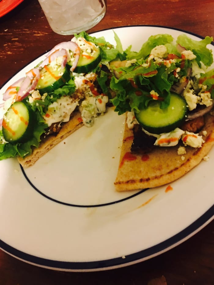 My burger served open faced on a whole wheat pita with cucumber, red onion, feta, romaine letter, tzatziki, pepperoncinis, and drizzled with a little hot sauce.