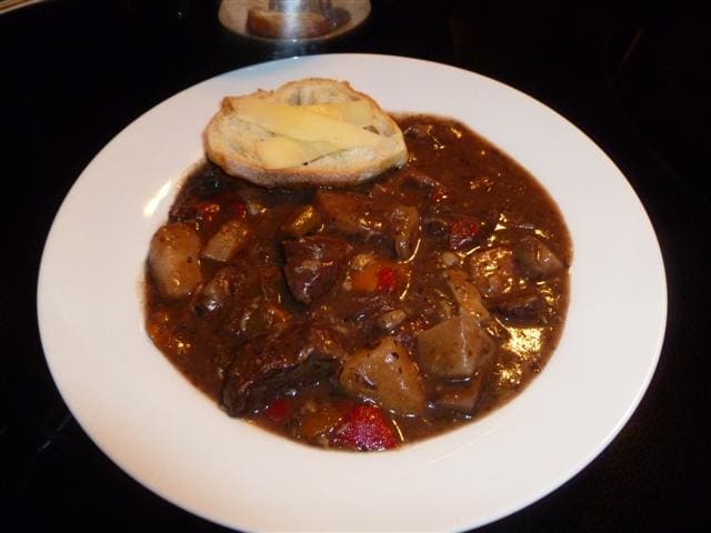Wonderful bowl of savory beef stew served with toasted crostini garnished with shaved Parmesan.