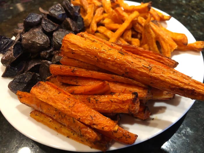 Roasted carrots, purple potatoes, and shoestring sweet potato fries come together in a sweet and savory vegetable medley.