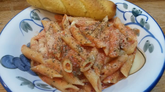 Vodka penne pasta served with garlic sticks