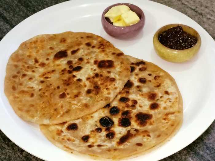 Aloo paratha is a traditional Punjabi breakfast dish, usually served with butter, lemon or mango pickle, and lassi.