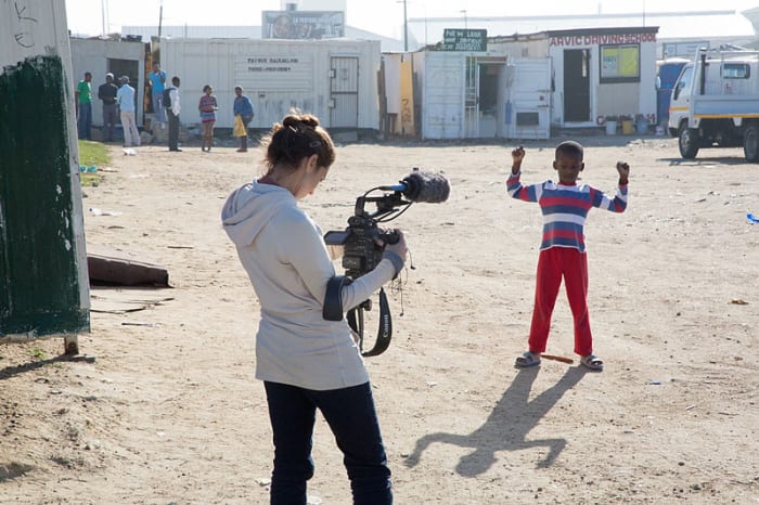 Townspeople look on during the filming of a documentary about Sinenjongo High School in Joe Slovo Park, Cape Town, South Africa.