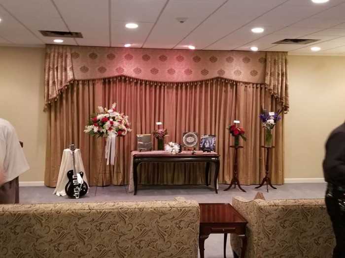 Kev's memorial - the urn with his ashes are behind the white heart shaped pillow with white roses.