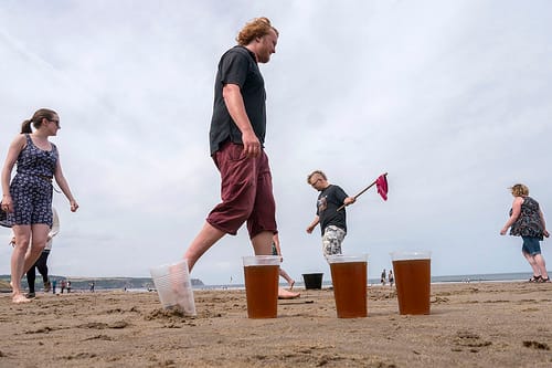 This is dwile flonking. It involves dancing around buckets of beer and avoiding a beer-soaked cloth launched from a stick.