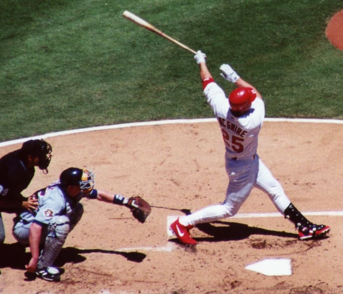 Mark McGwire is one of three players who reached the 50-homer mark four times.