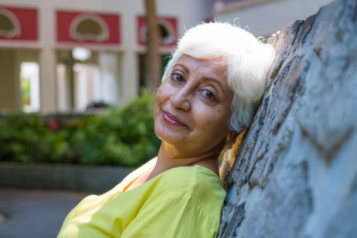 This woman is wearing lipstick that brightens up her face and doesn't feather at the edges of her lips.