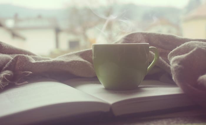 Allowing yourself to do things you enjoy, like reading a good book with a mug of hot chocolate, is one way to be kind to yourself.