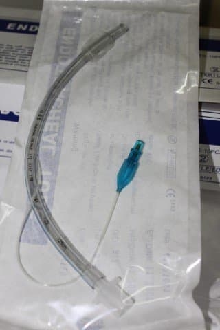The far end is placed into the windpipe through the vocal cords. The clear cuff is inflated by using a syringe on the blue pilot balloon. The other end of the tube protrudes from the mouth and has a connector that attaches to the ventilator.