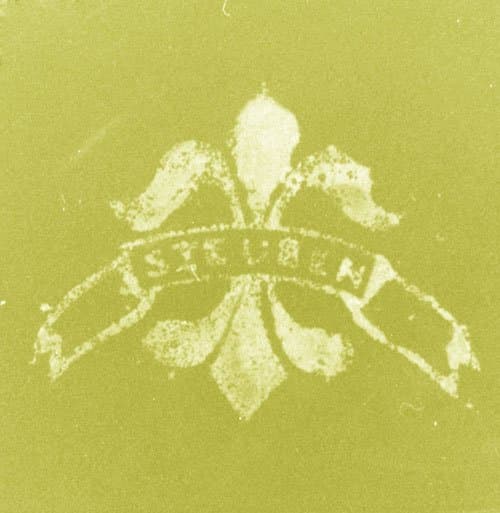 Typical forged acid fleur-de-lis mark. Blurred, illegible letters and a rough-edged outline.