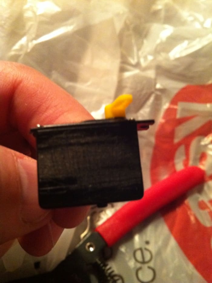 One side of the servo mounting tab is cut off. Removing both sides will make it that much easier to position them next to each other on the boom.