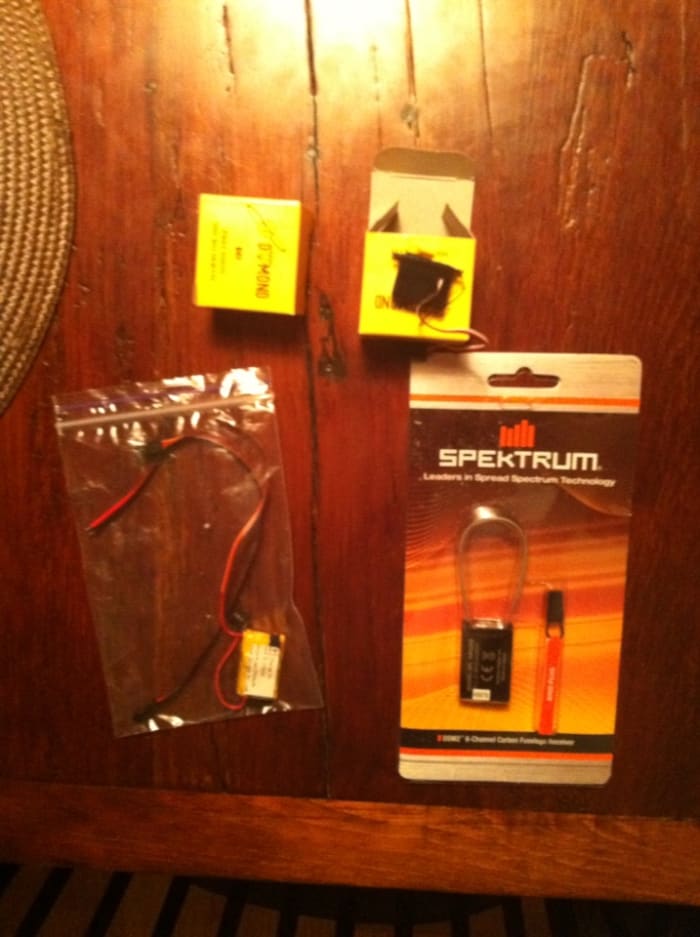 Finally! The receiver, smart LIPO battery and two tiny servos arrived and are ready to be installed. The AR6255 receiver was recommended due to the carbon fiber in the boom. Carbon may interfere with the reception from the transmitter.