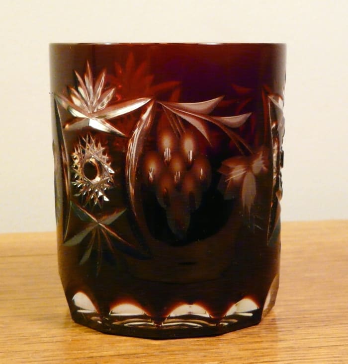 The pattern at the left is pressed into the glass, but the grapes and leaves at center and right are etched into the stain. It's about 3" tall.