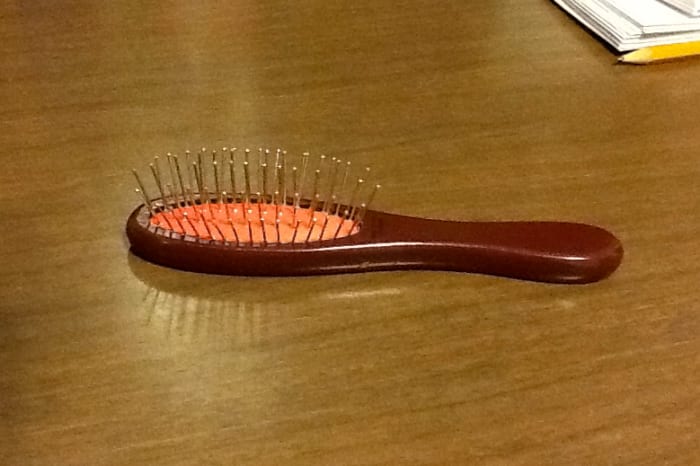 This is an official American Girl doll hairbrush. Note the widely spaced metal bristles that won't snag synthetic hair.