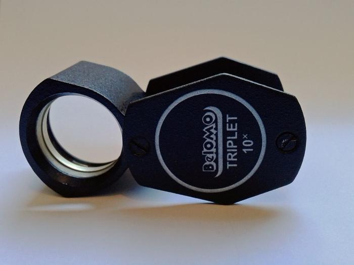 This loupe is made in Belarus and finished with black non reflecting surfaces and the lenses are fully multi-coated. A true triplet loupe has an optical system consisting of three compounded optical elements or lenses of different refractive indexes