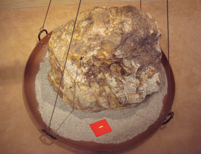 This image shows the relative sizes of an 860 kg block of gold ore, and the 30 g of gold that can be extracted from it.