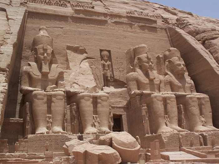 Abu Simbel temple showing large statues of Ramesses II flanked by smaller statues of his Queen Nefertari.