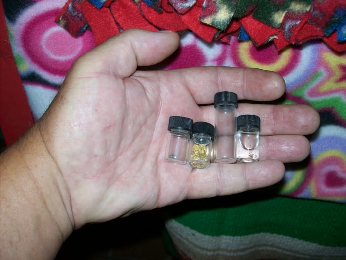 These are some of the vials I use. The left one has a piece of pyrite in it. Next are some placer gold flakes I have mined. The last vial contains small amounts of quartz I suspected had gold—often called "sugar" by old-timers.