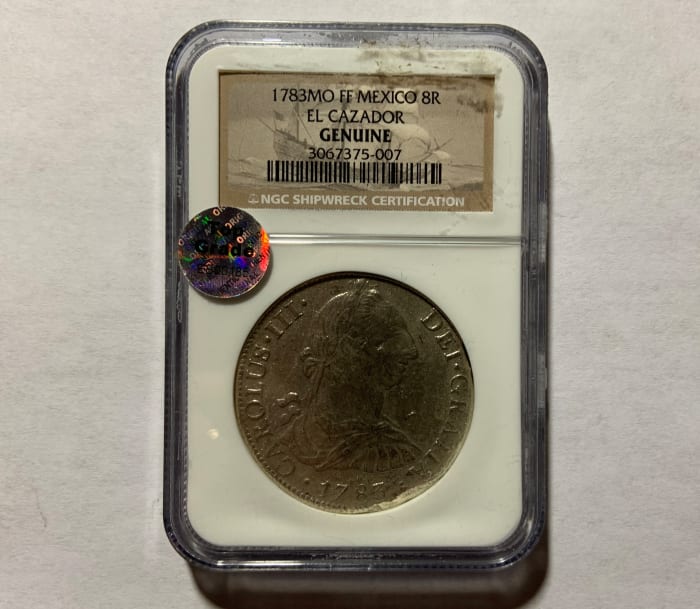 A professionally graded and authenticated coin. Not all holders say the word “Genuine”; it is implied by being in a professionally graded coin holder.
