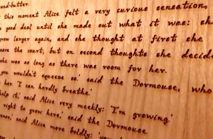 The engraved text on the wood pages was designed to resemble Lewis Carroll's handwriting.