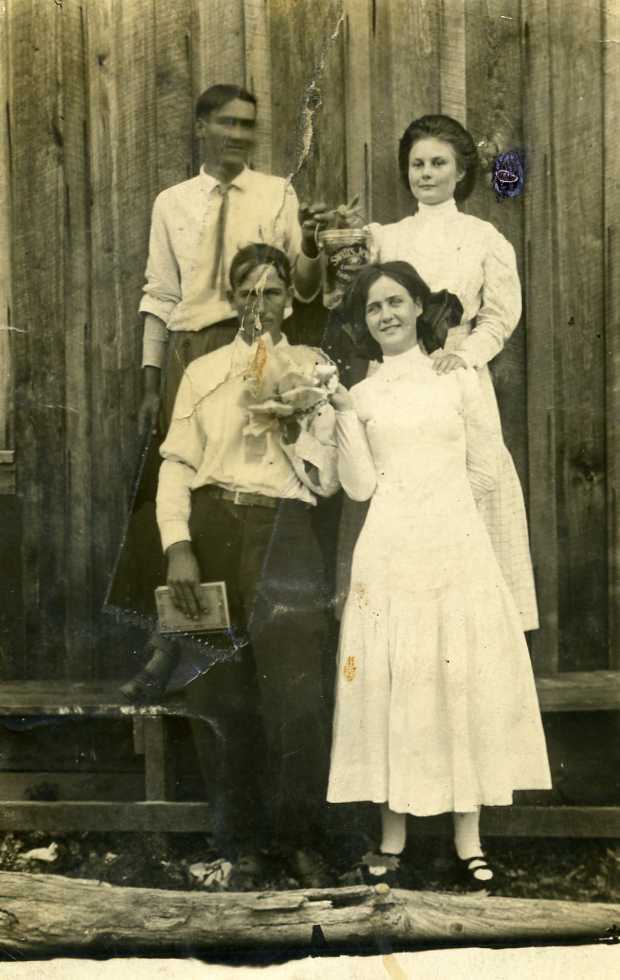 The lovely young lady in the back row is my maternal grandmother. This looks like it may have been taken at a church supper. No family member has been able to identify the other three young people in the photo, but neither man is my grandfather.