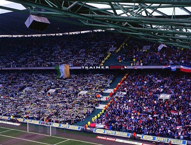 A photo showing both sets of fans at a match at Celtic Park. Celtic are on the left in green, Rangers are on the right in blue.